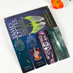 May include: A book titled James Potter and the Curse of the Gatekeeper by G. Norman Lippert, accompanied by four rectangular bookmarks. The bookmarks feature titles including Hall of Elders Crossing, Curse of the Gatekeeper, and Gryffindor crest.