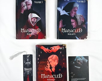 Könnte beinhalten: Eine Sammlung von Fantasy-Büchern und ein Lesezeichen. Die Bücher tragen den Titel "Manacled" mit den Bänden 1, 2 und 3. Die Cover zeigen Illustrationen von Charakteren in dunklen Farben. Ein Lesezeichen mit passendem Design ist ebenfalls enthalten.