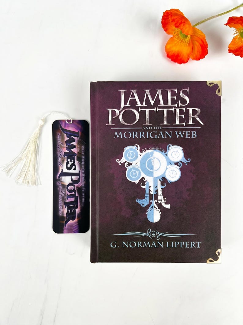 May include: A hardcover book titled James Potter and the Morrigan Web by G. Norman Lippert with a dark purple cover, gold corner accents, and a central clock graphic, accompanied by a matching vertical bookmark with a white tassel.