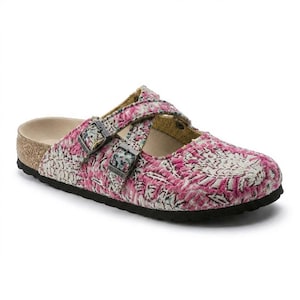 May include: Pink and white patterned clogs with two adjustable straps and metal buckles. The clogs have a cork footbed and a black sole. The design features a woven textile pattern.