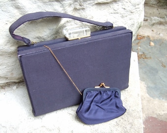 May include: A dark blue fabric purse with a gold chain and a clear plastic clasp. The purse has a matching dark blue fabric coin purse.