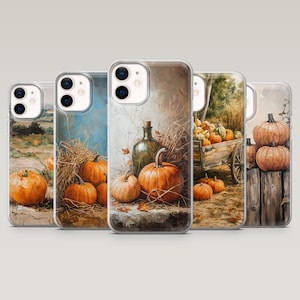 May include: Five clear phone cases featuring artistic illustrations of pumpkins in various autumn settings, including hay bales, wooden carts, and rustic fences, with warm orange, brown, and green tones depicted across the different designs.