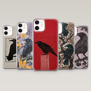 May include: Five phone cases with raven designs. The cases display different illustrations, such as a black raven on a red backdrop, a raven on a branch, and a raven silhouette. Each case has a clear border, offering protection while showcasing the artwork.