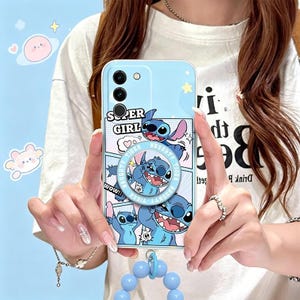 Pu&ograve; includere: Custodia per telefono azzurra con il personaggio Stitch di Lilo & Stitch. La custodia ha un anello pop-up con le scritte "Naughty Tiger" e "Super Girl". Un ciondolo di perline blu &egrave; attaccato.