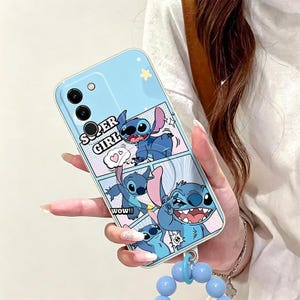 Pu&ograve; includere: Custodia per telefono azzurra con un design a fumetti con il personaggio Stitch. La custodia ha le parole "SUPER GIRL" e "WOW!!" stampate sopra. Un cinturino da polso con perline blu &egrave; attaccato in basso.