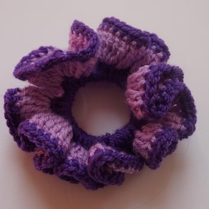May include: Purple and lavender crocheted hair scrunchie with a ruffled design.