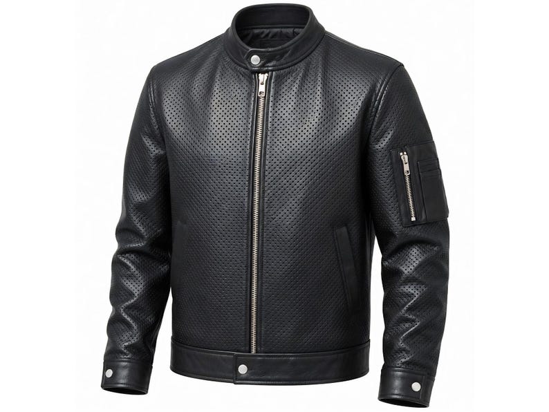 Puede incluir: Una chaqueta de cuero negro perforado con cuello alzado y bot&oacute;n a presi&oacute;n, cremallera frontal plateada de longitud completa y un bolsillo utilitario con cremallera en la manga izquierda. Los pu&ntilde;os y el dobladillo tienen cuero liso y botones.