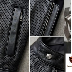 Puede incluir: Una chaqueta de cuero negro perforado con un bolsillo vertical con cremallera, un cierre de cremallera frontal completo y un cuello alzado asegurado con un bot&oacute;n de presi&oacute;n de metal plateado. El logotipo de Fabbrica Industries es visible.