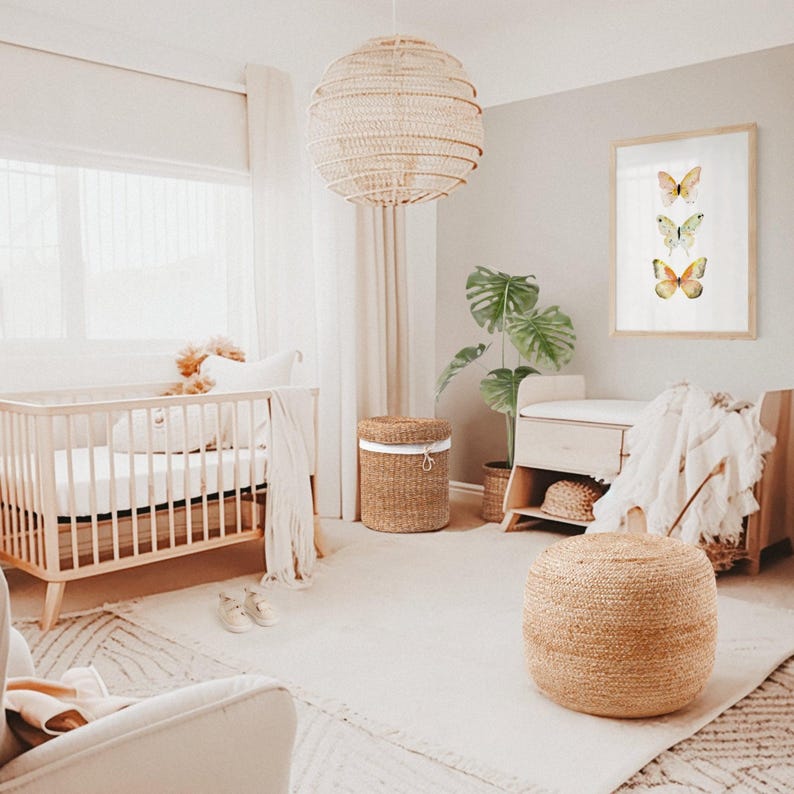 Peut inclure: Une chambre d'enfant lumineuse avec un lit en bois, une suspension en osier et une impression encadr&eacute;e de papillons. La pi&egrave;ce pr&eacute;sente une palette de couleurs neutres avec un tapis, un panier en osier et un pouf. Une grande plante verte ajoute une touche de nature.