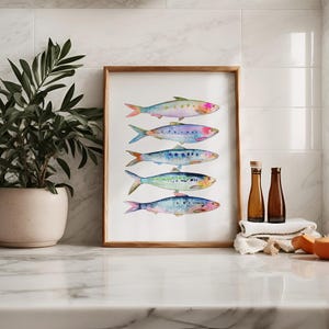 May include: A framed watercolor painting of six colorful fish arranged vertically. The fish are painted in shades of blue, green, purple, and pink, with a white background.