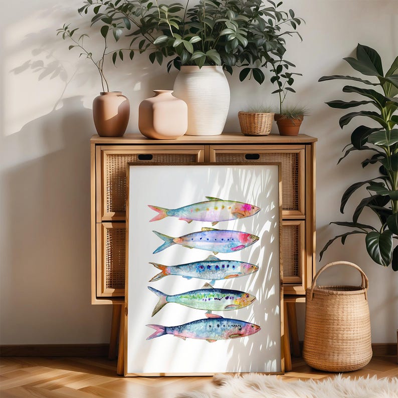 May include: A white framed print with a watercolor illustration of six colorful fish on a white background. The fish are arranged in a vertical line, with the largest fish at the top and the smallest fish at the bottom. The fish are all facing to the right.