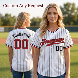 Peut inclure: Maillot de baseball blanc à fines rayures noires, avec des accents rouges et noirs, et le texte "Jeanname" en script rouge. Le maillot porte également le numéro "00" en noir. Le texte "Custom Any Request" est en haut.