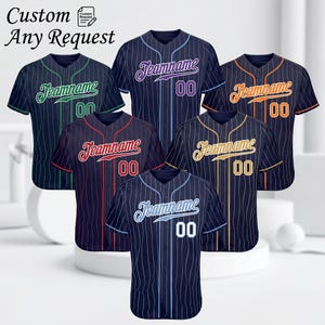 Könnte beinhalten: Baseball-Trikots in verschiedenen Farben, darunter Marineblau, Grün, Rot, Orange und Gold, mit vertikalen Streifen. Jedes Trikot hat einen Teamnamen und die Nummer "00". Der Text "Custom Any Request" ist oben zu sehen.