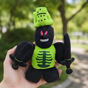 May include: A black plush toy figure with a green skeleton vest, holding two black swords. The figure has a green domino hat and pink eyes. The toy is designed with a cartoonish aesthetic.