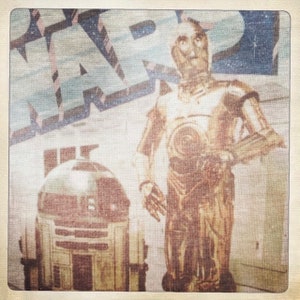 Puede incluir: Un p&oacute;ster vintage de Star Wars con C-3PO y R2-D2. El p&oacute;ster tiene un aspecto descolorido y desgastado, y el texto "Star Wars" es visible en la parte superior.