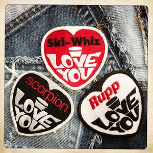 May include: Three heart-shaped patches with the words "Love You" in white lettering on a black, red, and white background. The patches also have the words "Ski-Whiz", "Rupp", and "Scorpion" on them.