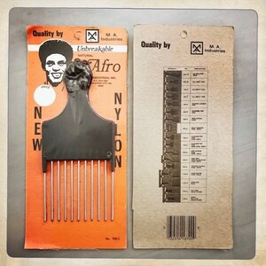 May include: A close-up of a black plastic comb with metal teeth. The comb is labeled "Unbreakable Natural Afro" and "Nylon". The packaging is orange and features a black and white image of a man with an afro.