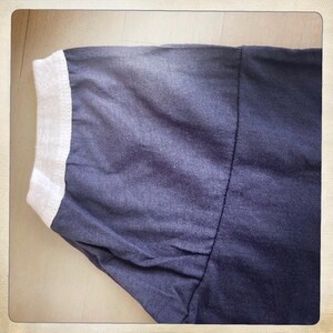 Op de afbeelding: Een donkerblauw T-shirt met een witte geribbelde kraag. Het shirt is gemaakt van een zachte, comfortabele stof.