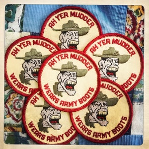 Puede incluir: Seis parches bordados de color amarillo y rojo con el texto "Ah Yer Mudder Wears Army Boots".