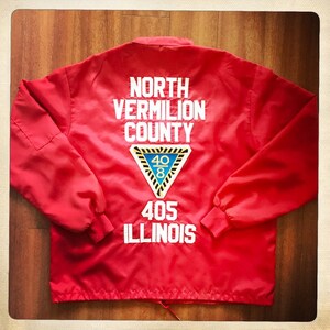 May include: Red jacket with "NORTH VERMILION COUNTY 408 405 ILLINOIS" text on the back. The jacket has a zipper closure and a drawstring at the bottom.