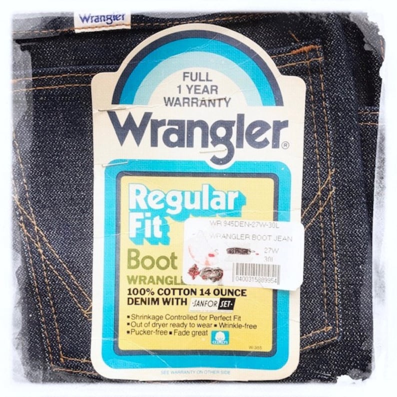 May include: A vintage Wrangler Regular Fit Boot Cut Jean label with a blue and yellow color scheme. The label features the Wrangler logo, the words "Regular Fit" and "Boot Cut", and the text "100% Cotton 14 Ounce Denim with Sanfor-Set".
