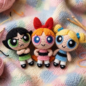 Puede incluir: Tres muñecas de Powerpuff Girls hechas a ganchillo. Pétalo tiene el pelo negro y un vestido verde. Pétalo tiene el pelo naranja y un vestido rosa. Burbuja tiene el pelo rubio y un vestido azul. Cada muñeca tiene ojos grandes y una cara sonriente.