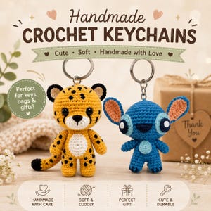 May include: Two handmade crochet keychains featuring a yellow and black spotted cheetah and a blue alien character with large ears. Both figures have black plastic eyes and are attached to silver metal key rings. Text includes Handmade Crochet Keychains.