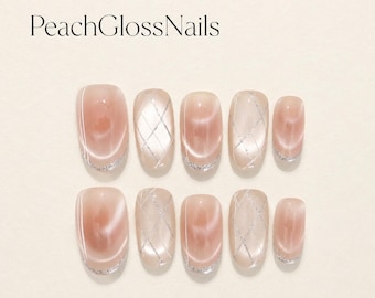 Unhas de gel squoval com efeito olho de gato em tom pêssego blush, francesinha prateada, grade de diamante.