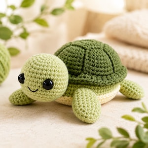Op de afbeelding: Een handgemaakte gehaakte schildpad met een lichtgroene kop, grote zwarte plastic ogen en een geborduurde glimlach. Het schild is donker bosgroen met een textuurpatroon, terwijl de onderkant van het lichaam een zachte crèmekleur heeft.