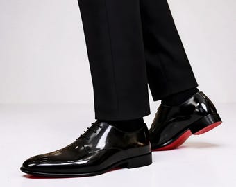 Christian Louboutin black patent leather men's dress shoes with a signature red sole.