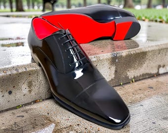 Greggo Oxford-herenschoenen van Christian Louboutin zijn gemaakt van zwart lakleder en hebben de iconische rode zolen van het merk.
