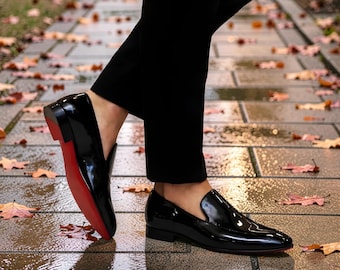 Mocassini Dandelion di Christian Louboutin in pelle verniciata nera con la caratteristica suola rossa del marchio.