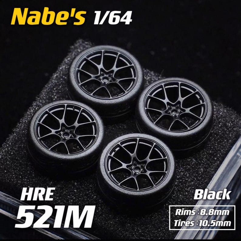 May include: Four black model car wheels with a multi-spoke design. The wheels are labeled "HRE 521M" and "Black". The rims measure 8.8mm and the tires are 10.5mm. The text "Nabe's 1/64" is also visible.