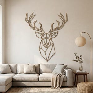 Op de afbeelding: Een groot, bruin, geometrisch wandkunstobject in de vorm van een hertenkop met complexe, hoekige lijnen die het gewei en de gelaatstrekken vormen. De hertenkop is centraal bevestigd aan een effen, lichte muur boven een neutrale bank.