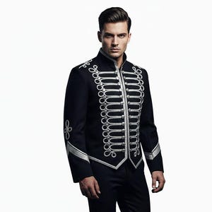 May include: Black military-style jacket with silver embellishments and matching black pants. The jacket features a high collar and decorative silver trim along the front, cuffs, and shoulders. The outfit is a formal style.