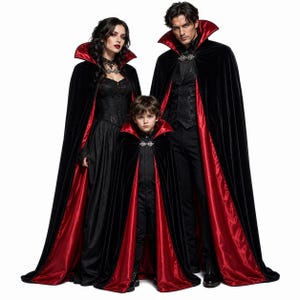 May include: Three matching floor-length capes featuring black velvet exteriors and vibrant red satin linings. Each cape includes a high standing collar and a decorative silver-toned metal clasp at the neck, designed for formal or theatrical attire.