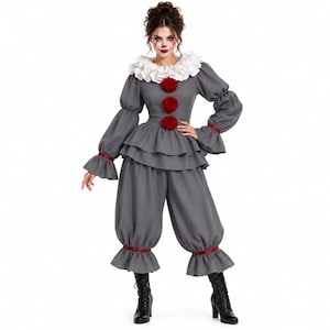 Puede incluir: Un disfraz de payaso gris con cuello de volantes blanco, mangas largas con puños de volantes y una parte superior con peplum en capas. El conjunto incluye tres pompones rojos en la parte delantera, ribetes rojos a juego en mangas y pantalón, y pantalones holgados.
