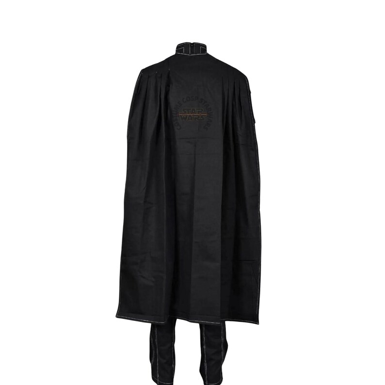 May include: A black floor-length cape with a high collar and white contrast stitching along the edges. The back features a circular embroidered Star Wars logo. The garment is paired with matching black trousers that also display white contrast stitching.