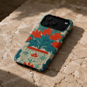 May include: A smartphone case featuring a textured, cream-colored background with a repeating pattern of vibrant orange flowers and teal green foliage. The design includes a stylized orange and teal pot motif, with a black camera cutout area.