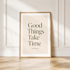 Może przedstawiać: Prostokątny wydruk ścienny w jasnej drewnianej ramie z beżowym tłem i ciemnooliwkowym napisem "Good Things Take Time" wyśrodkowanym czcionką szeryfową, z krótką poziomą linią umieszczoną pod tekstem.