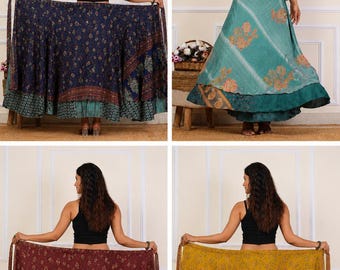 May include: A collection of four floor-length wrap skirts featuring diverse floral and geometric patterns in navy blue, teal, maroon, and mustard yellow. Each skirt has a layered design with a tie-waist closure and a flared, flowing silhouette.