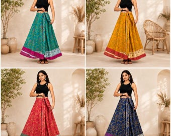 May include: A collection of four floor-length wrap skirts, each featuring a black sleeveless top. The skirts are available in teal, mustard yellow, red, and navy blue, all decorated with a gold floral pattern and a contrasting patterned hem.