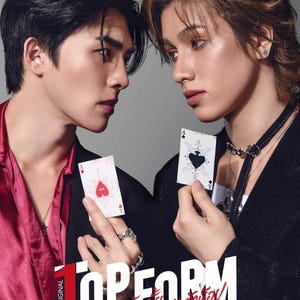 May include: Two people are facing each other, each holding a playing card. One card has a heart design, the other a spade. The image has the text "TOPFORM" and other text in a foreign language. The background is a solid gray.