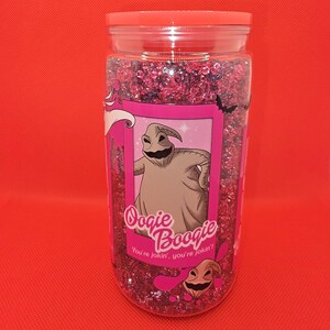 K&ouml;nnte beinhalten: Ein durchsichtiges Plastikglas gef&uuml;llt mit rosa Glitzer und einem rosa Deckel. Das Glas hat ein rosa Etikett mit einer Illustration von Oogie Boogie aus The Nightmare Before Christmas, mit dem Text "Oogie Boogie" und "You're jokin', you're jokin'!"