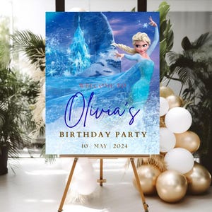 May include: A rectangular birthday party sign featuring a blue ice castle background and a blonde character in a light blue dress. The text reads: WELCOME TO, Olivia's, BIRTHDAY PARTY, 10 | MAY | 2024. The sign is displayed on a wooden easel.