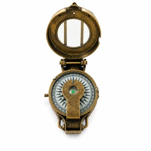 May include: An antique-style brass compass with a hinged lid and a circular glass viewing window. The compass features a white dial with black directional markings, a central metal bridge, and a small green accent at the center of the needle.