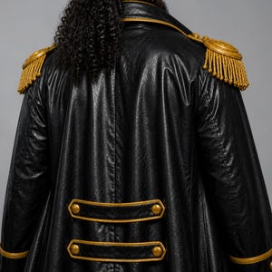 May include: Black faux leather coat with gold trim and epaulets. The coat features gold buttons and trim along the collar and cuffs. The epaulets are gold with gold fringe.