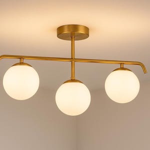 Modern brass light flush mount, opal glass globe, warm ambient light