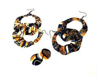May include: A pair of large hoop earrings made of fabric with a blue, white, and orange pattern. The earrings are layered and have a unique, handmade look. There is also a smaller pair of earrings with the same pattern.