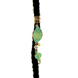 May include: A gold and turquoise leaf-shaped hair bead with a gold wire wrap and a turquoise seahorse charm hanging from it.